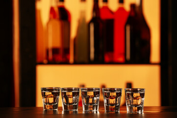 Shots of cold vodka on table in bar