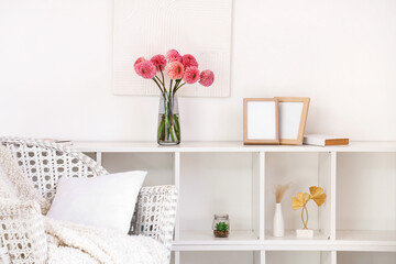 Vase of beautiful pink dahlias on shelving unit in living room