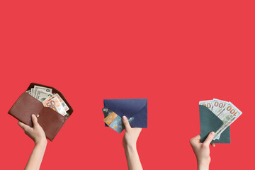 Female hands with wallets, envelopes and money on red background - obrazy, fototapety, plakaty