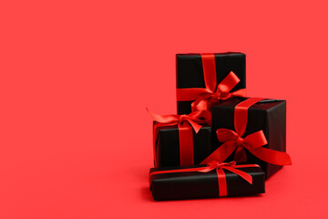 Many gift boxes on red background. Black Friday