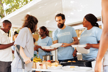 Multiethnic group of volunteers provides aid, handing out free food to disadvantaged communities....