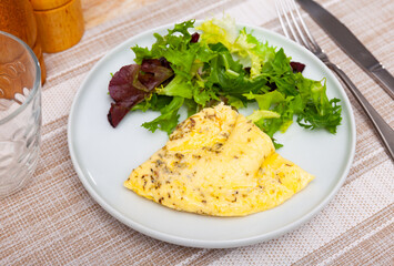 Traditional dish of French cuisine is an omelet cooked in a frying pan from lightly beaten eggs...