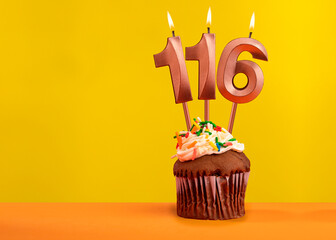 Candle with flame number 116 - Birthday card on yellow background