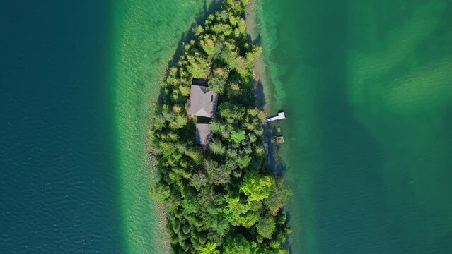 Aerial view of amazing private island at Lake Manitou, nestled in the quiet charm of tranquil waters. Manitoulin Island clean waters surrounding beautiful retreat cottages on the small island.