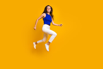 Full length photo of shiny sweet woman wear blue top jumping high running fast empty space isolated...