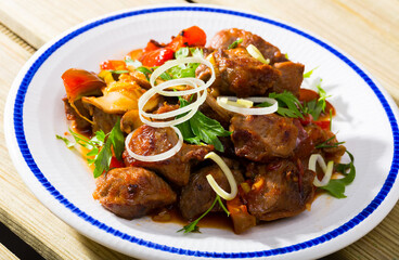Delicious meat stew with bell pepper, tomatoes and mushrooms (Kavarma) served fresh greens. Bulgarian cuisine