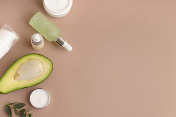 Set of different cosmetic products and avocado on color background