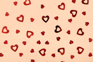 Composition with heart-shaped sequins on color background. Valentine's Day celebration