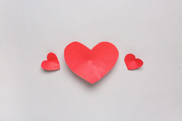 Fototapeta premium Three red paper hearts on a white background, love and romance concept