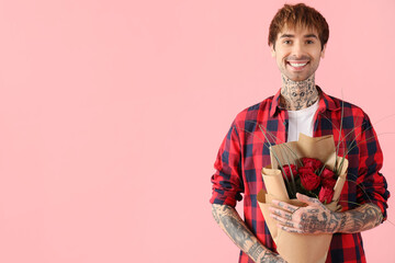 Handsome young man with bouquet of roses for Valentine's day on pink background