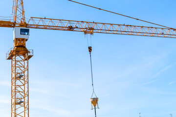Construction crane tower on blue sky background. Crane and building working progress. Worker. Construction concept. New buildings with a crane. Tower crane