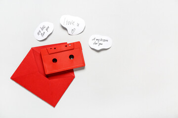 Red envelope, vintage audio cassette and declarations of love on grey background. Valentine's Day...