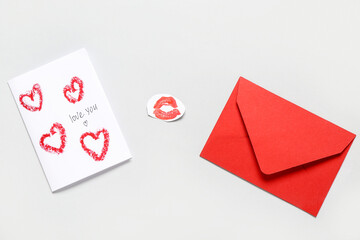 Greeting card for Valentine's Day celebration, red envelope and lipstick kiss mark on grey background