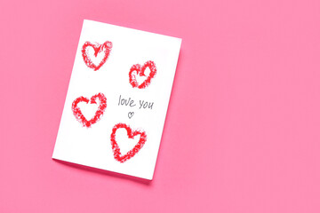 Greeting card with text LOVE YOU on pink background. Valentine's Day celebration