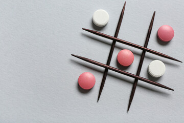 Tic tac toe game with pills and toothpicks on grey background - obrazy, fototapety, plakaty