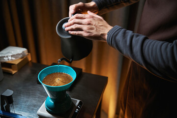 Fototapeta na wymiar Barista uses pour over dripper filter alternative coffee brewing method