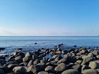 Jeju Island's sea with black basalt rocks.
