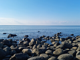 This is a Jeju beach with blue skies and basalt rocks