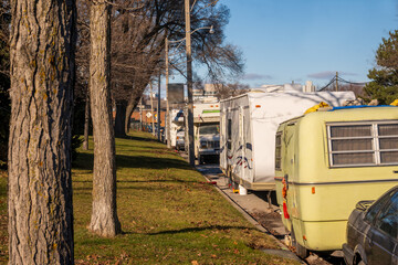 housing crisis: older travel trailers being lived in on a public street in an industrial section of...
