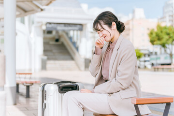 駅・旅行中に体調不良になったビジネスウーマン
