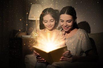 Shiny magic book with letters flying over it. Girl with her mother reading fairy tale at home