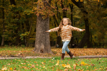 Happy girl running in autumn park, space for text