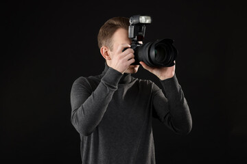 Professional photographer taking picture on black background