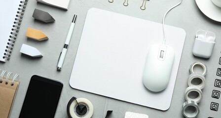 Flat lay composition with wired computer mouse and stationery on light grey table