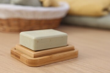 Soap bar on light wooden table, space for text. Spa therapy