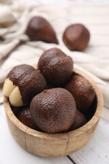 Fresh salak fruits in bowl on table, closeup