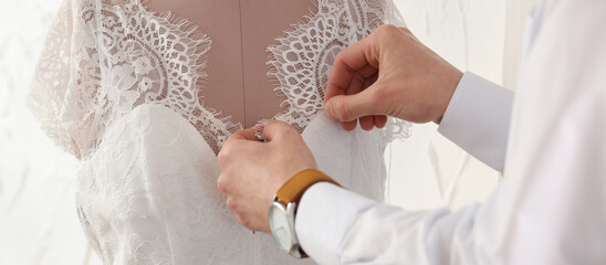 Dressmaker working with wedding dress on mannequin in workshop, closeup. Banner design