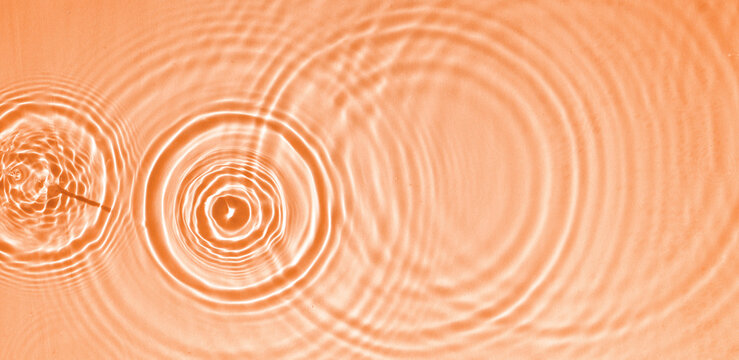 Circles and waves on blue water in sunlight Transparent blue water surface texture with splashes and circles Abstract natural backdrop