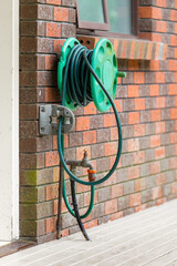 Watering garden equipment. Old garden hose, reel and adjustable spray gun, Dirty old garden hose...