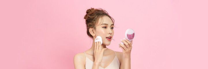 Portrait of beautiful asian woman applying powder puff at cheek makeup of cosmetic,