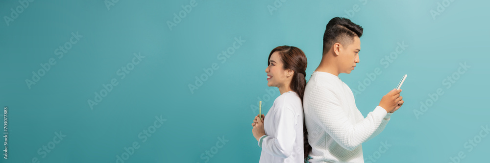 Wall mural infidelity, suspicion asian young couple love standing back to back,