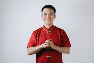 Smile face of Asian man wearing Chinese traditional cloth called Cheongsam with a gesture of...