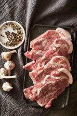 Raw neck meat seasoned with spices on a plate	