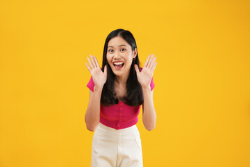 Excited asian woman shout out loud wow with hands on isolated background. Happy shocked face female wow promotion advertising concept. Isolated on yellow background