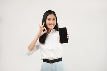 Portrait of a young Asian woman smiling a positive sign of OK at a phone advertisement, and wearing a white shirt, isolated on a white background. 