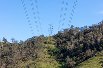 Photograph of a large telecommunications tower located on a green and grassy hill in the Blue Mountains in regional Australia