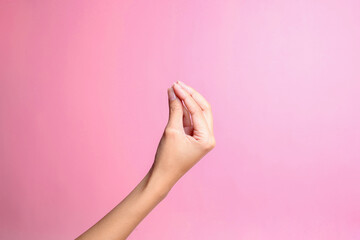 Hand doing Italian gesture with fingers together isolated over pink background