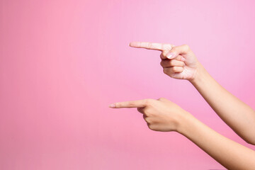 Two hands points to something with index finger over pink background, cut out - obrazy, fototapety, plakaty