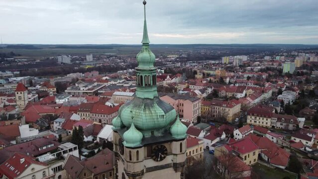 Aged top of the castle dome in the middle of Czech town with small houses