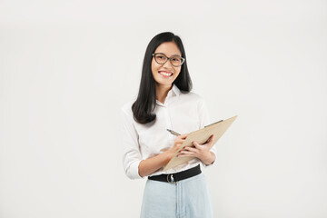 An Asian woman smiles warmly while writing on a clipboard, exuding confidence and positivity in a...