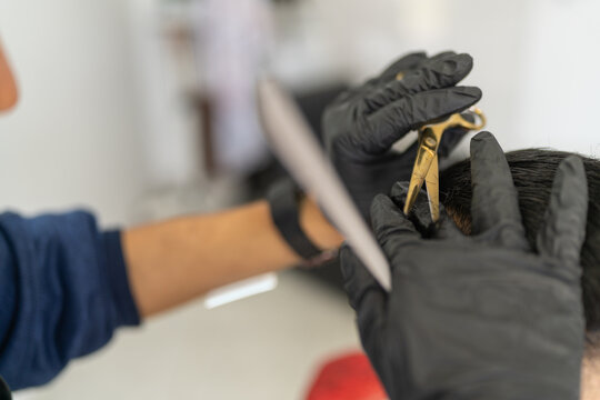 Close-up of the hands of a barber cutting hair