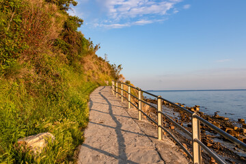 Fototapeta premium Scenic walking path between Fiesa and charming coastal town of Piran in Slovenian Istria, Slovenia, Europe. Rugged rocky cliffs gracefully perched above shimmering waters of the Adriatic Sea. Seascape
