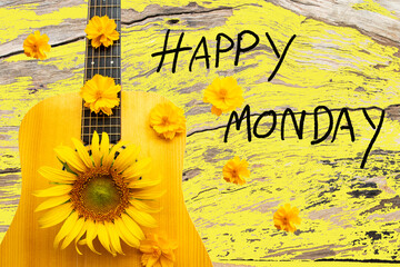 happy monday message card handwriting with flowers and guitar arrangement flat lay postcard style on background yellow wooden