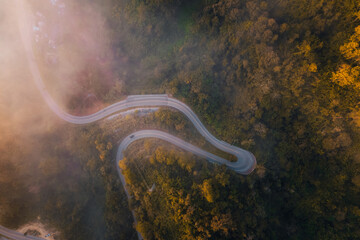 Obraz na płótnie Canvas Aerial view of road in mountain valley at sunrise