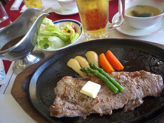 Japanese lunch set with sirloin steak served on iron pan, miso soup, vegetable salad and beer 