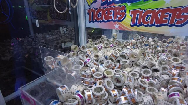 Claw machine at an arcade grabbing tickets